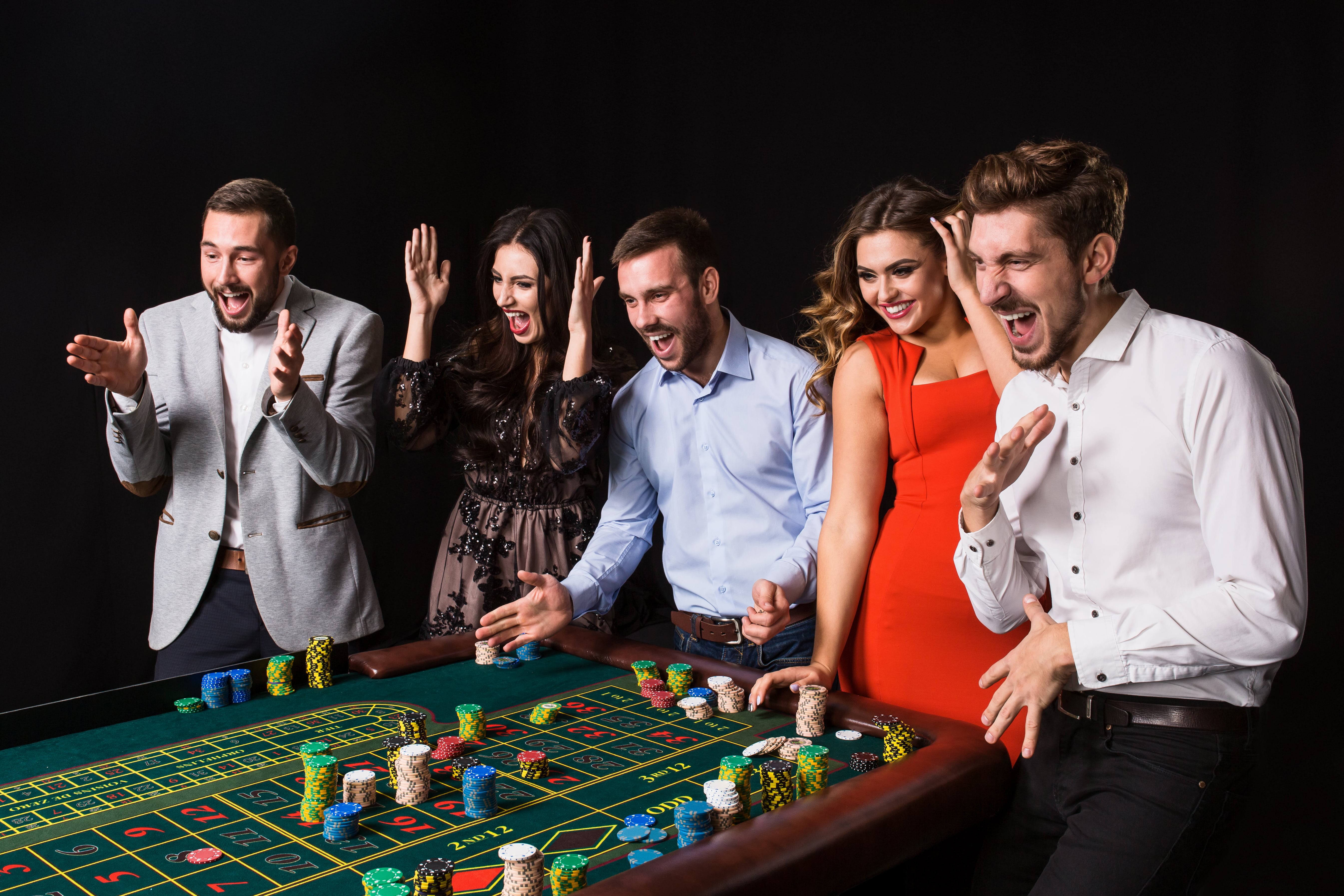 group-young-people-roulette-table-black-background-young-people-made-bets-game-wait-result-bright-emotions-min group young people roulette table black background young people made bets game wait result bright emotions min